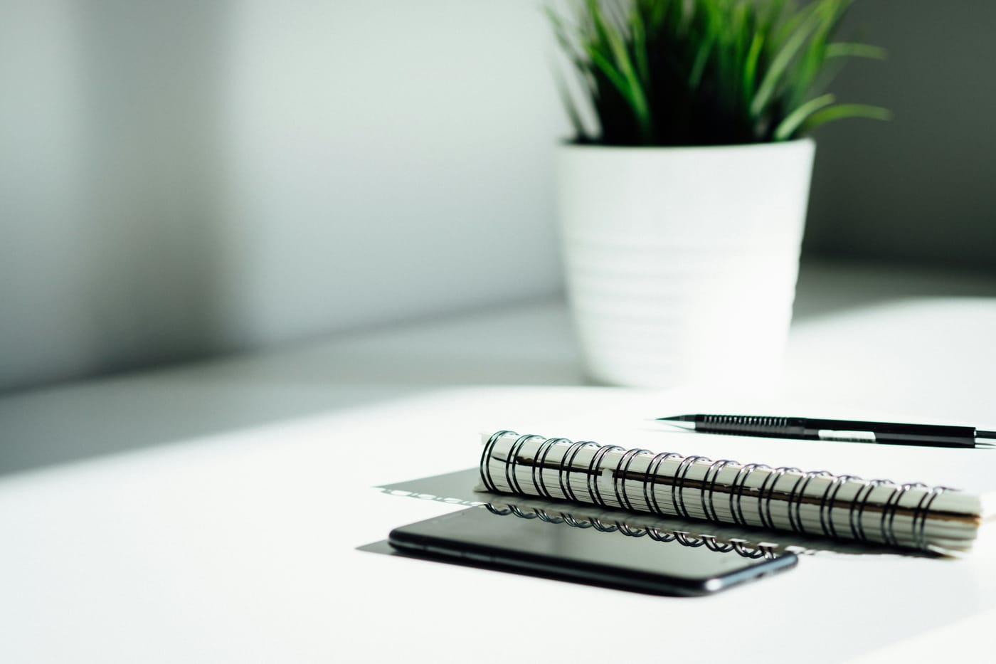 Caderno e celular sobre uma mesa, usados para registrar o contato de um cliente antes da Black Friday