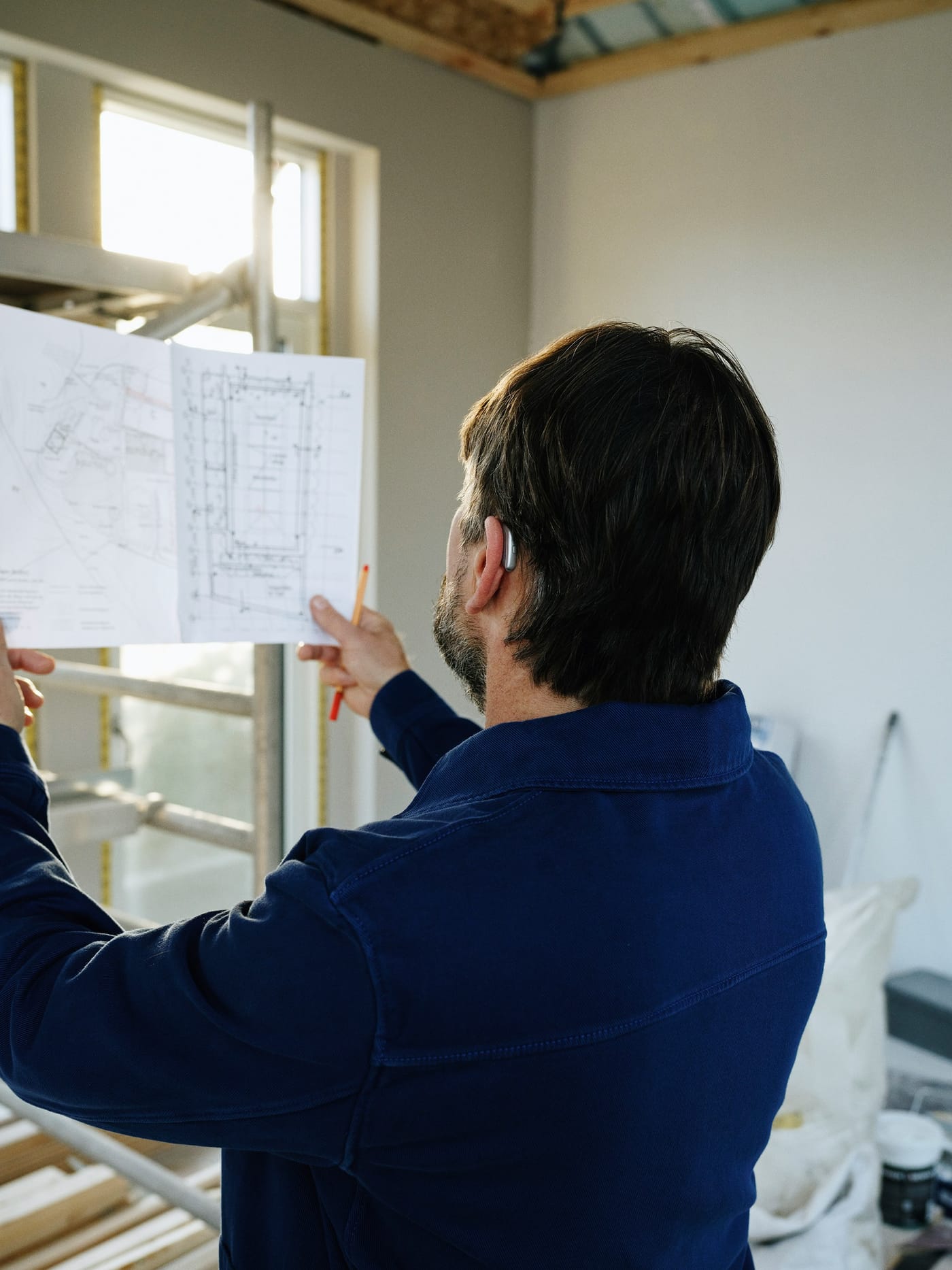 Engenheiro conferindo a planta de uma obra residencial em reforma