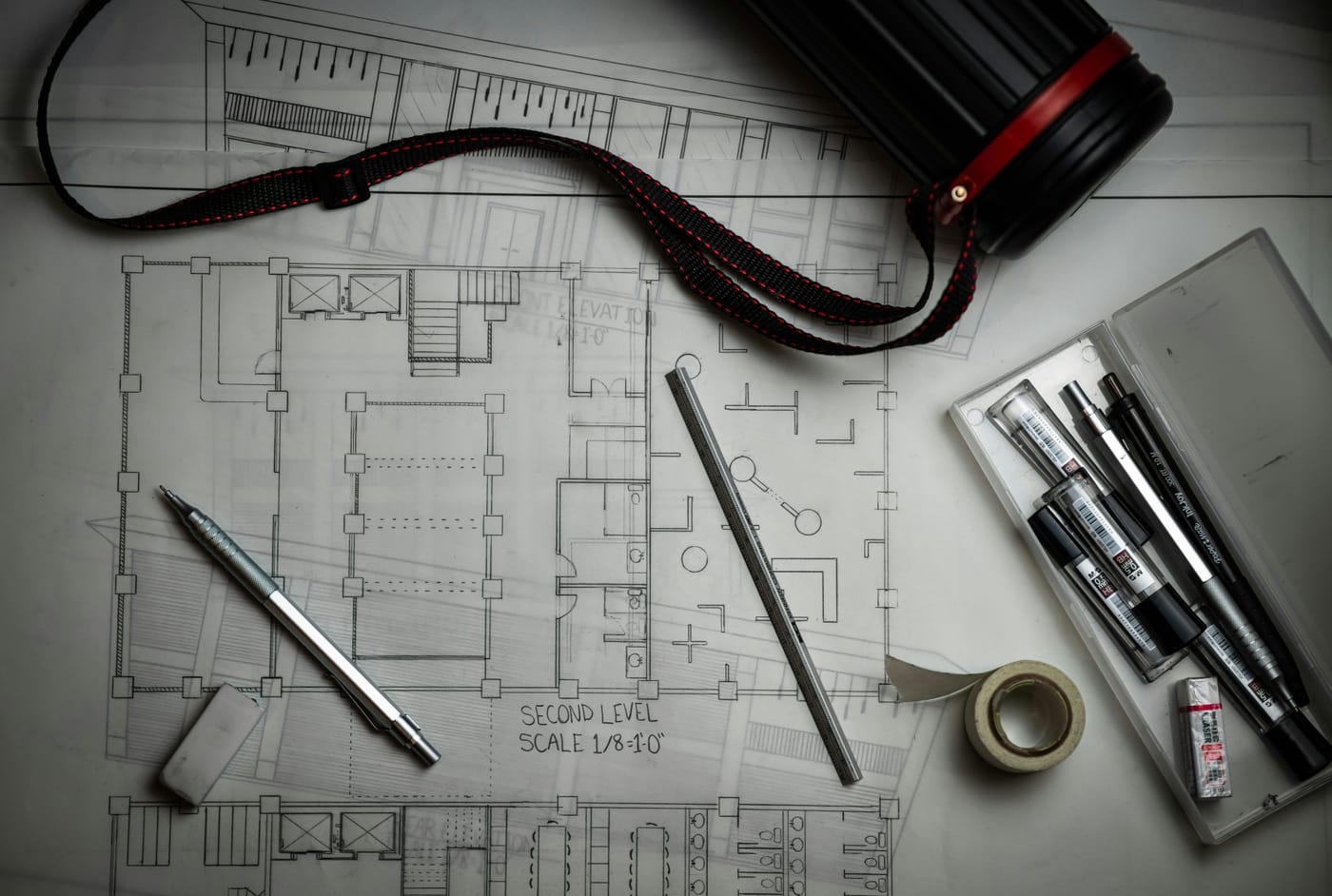 Pranchetas e material de desenho sobre a mesa de um escritório de arquitetura