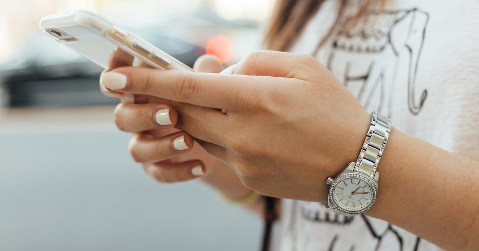 Mulher conferindo o relógio enquanto segura o celular, ilustrando o tempo de resposta no atendimento pelo WhatsApp