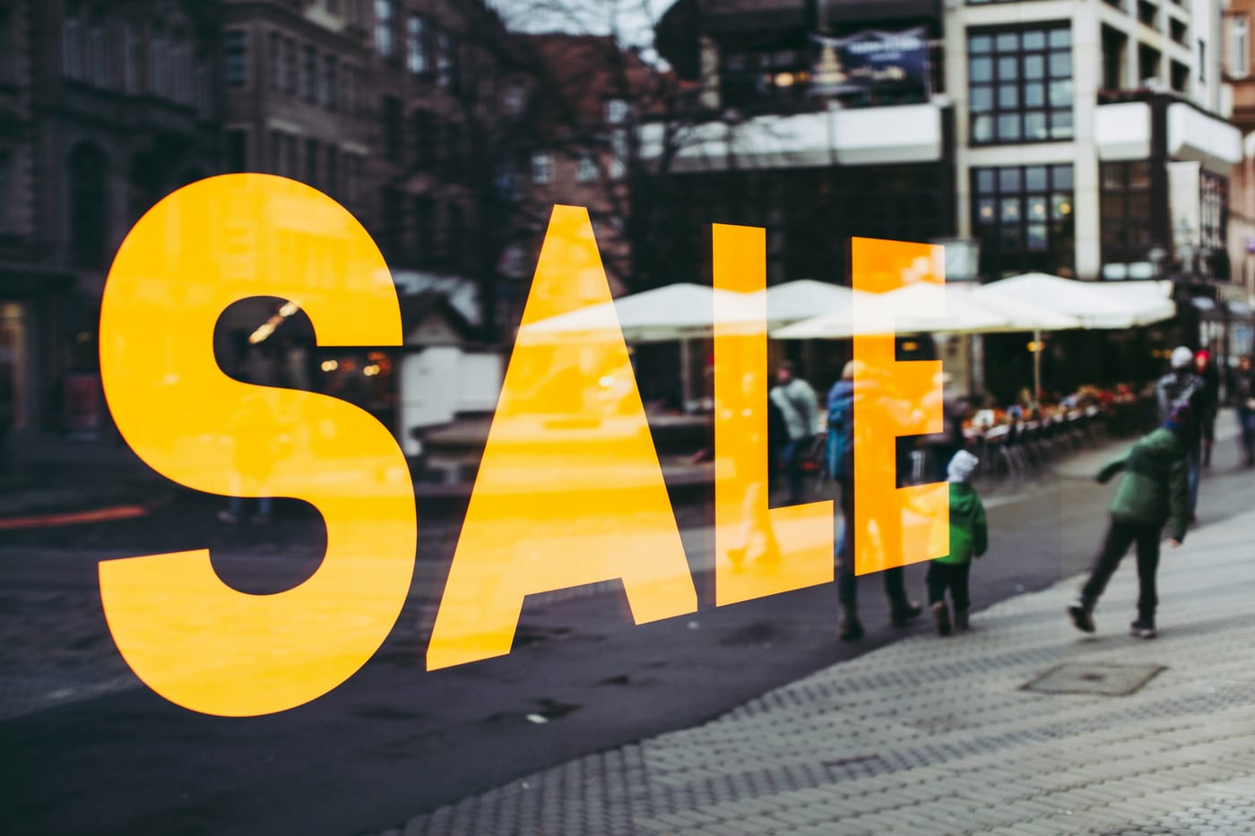 Placa amarela de SALE na vitrine de uma loja, ilustrando a promoção de Black Friday